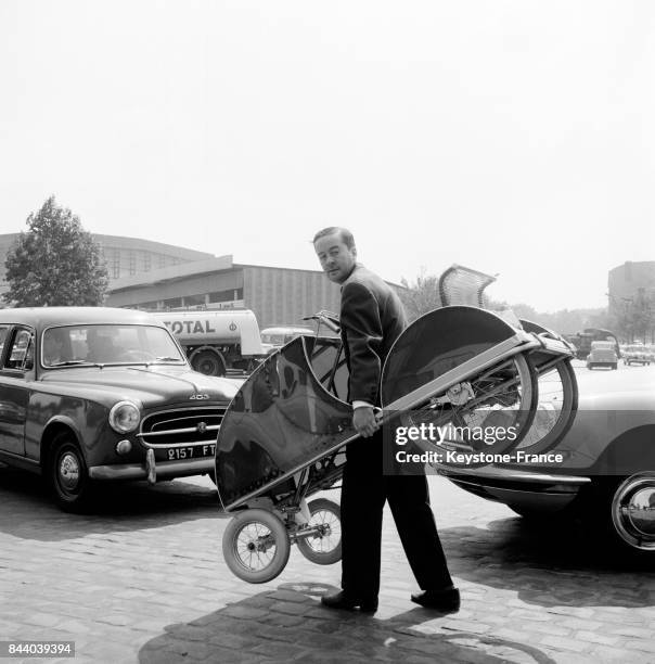 Arrivant dans son Oto-pédal, l'inventeur est ravie de pouvoir circuler malgré les embouteillages, à Paris, France le 18 mai 1961.