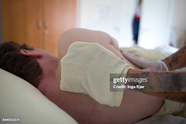 Eberswalde-Finow, GERMANY A geriatric nurse washes a resident's back on August 08, 2017 in Eberswalde-Finow, Germany.