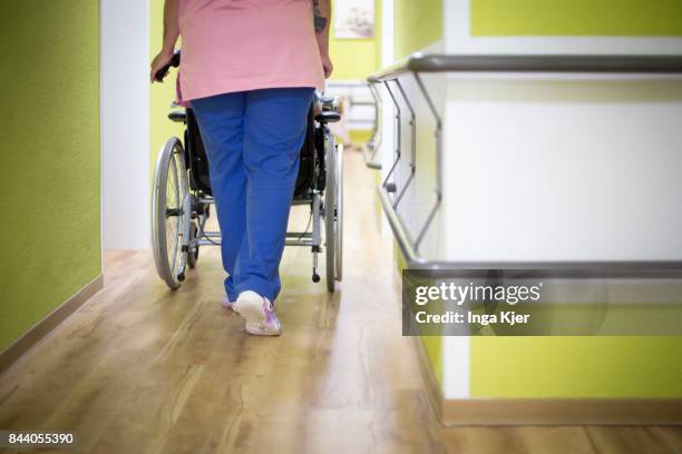 Eberswalde-Finow, GERMANY A geriatric pushes a resident in a wheel chair down the hall way on August 08, 2017 in Eberswalde-Finow, Germany.