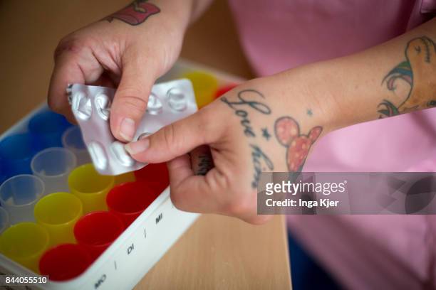Eberswalde-Finow, GERMANY A geriatric nurse pushes pills out of their box on on August 08, 2017 in Eberswalde-Finow, Germany.