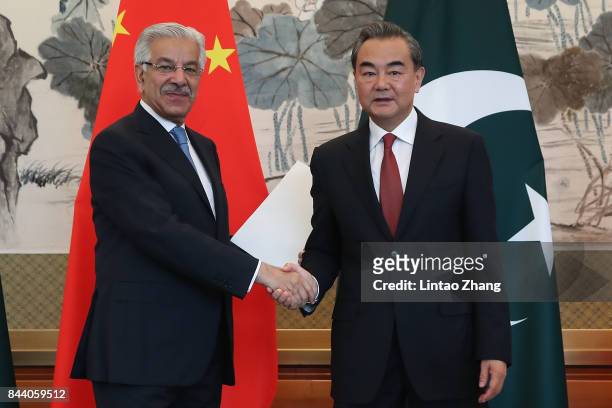 Chinese Foreign Minister Wang Yi shakes hands with Pakistan Foreign Minister Khawaja Muhammad Asif during a press conference at Diaoyutai State...