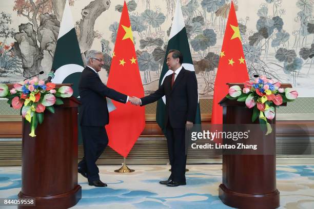 Chinese Foreign Minister Wang Yi shakes hands with Pakistan Foreign Minister Khawaja Muhammad Asif during a press conference at Diaoyutai State...