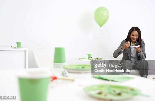 businesswoman eating birthday cake - messy table after party stock-fotos und bilder