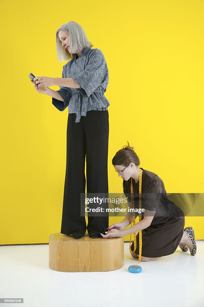Woman at tailor checking text messages