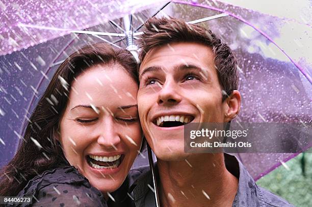 couple laughing in rain under purple umbrella - 2008 stock-fotos und bilder