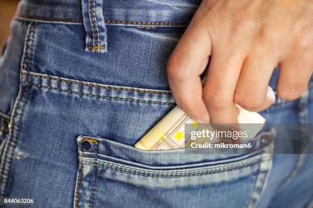 man putting a wad of cash into the pocket of his jeans - phone in back pocket stock pictures, royalty-free photos & images