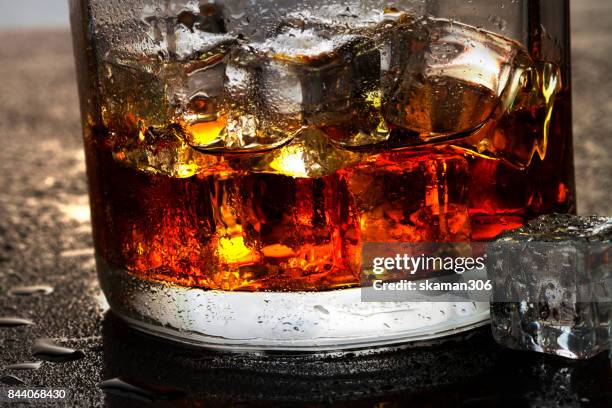 selective focus pure whisky with ice cube inside whisky glass on wet background - whisky glass stock pictures, royalty-free photos & images
