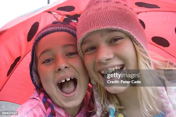 two girls under umbrella - girl 11 12 laughing close up foto e immagini stock