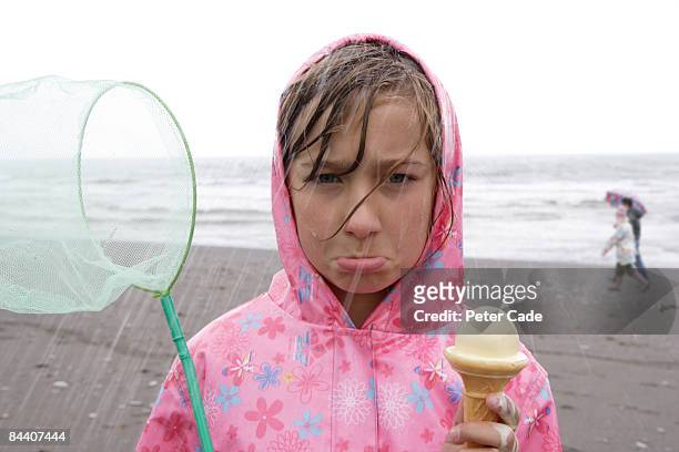 girl on beach in rain - standing in the rain girl stockfoto's en -beelden