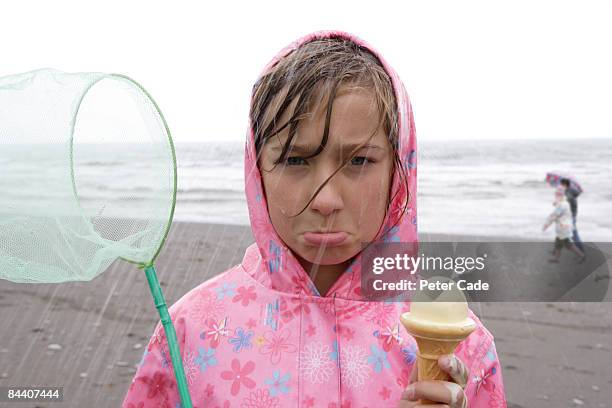 girl on beach in rain - rainy beach stock pictures, royalty-free photos & images