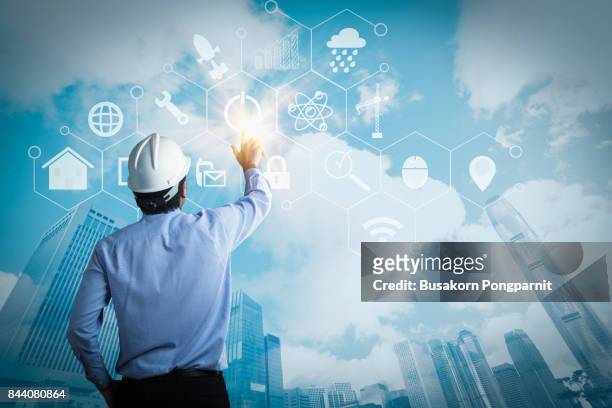 young engineer activating touch screen on blue background - oil rig engineers stock pictures, royalty-free photos & images