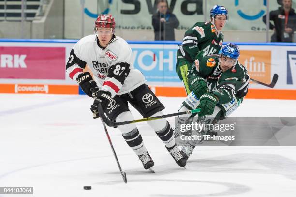Philip Gogulla of Koelner Haie and Trevor Parkes of Augsburger Panther battle for the ball during a friendly match between Augsburger Panther and...