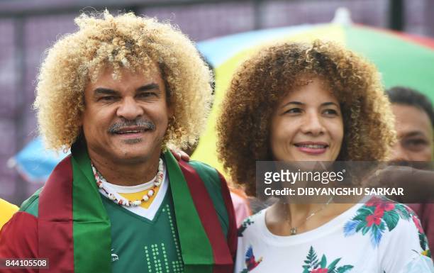 Former Colombian footballer Carlos Valderrama, who played in three World Cup tournaments, poses for pictures with his wife Elvira while holding a...
