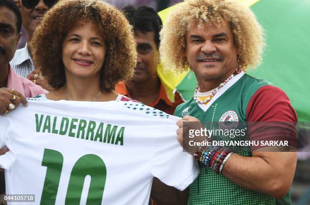 Former Colombian footballer Carlos Valderrama, who played in three World Cup tournaments, poses for pictures with his wife Elvira during an event...