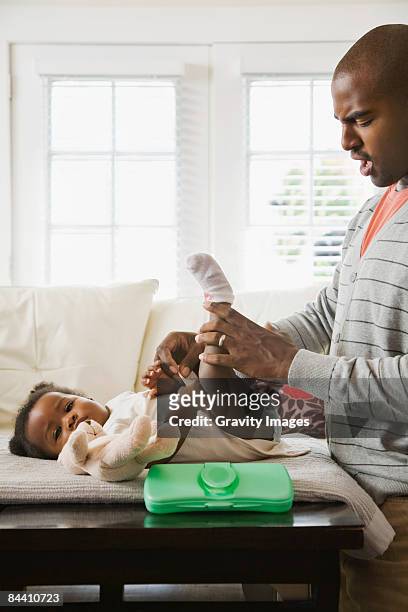 father changing baby's diaper - changing diaper photos et images de collection