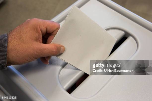 Federal election 2017. Symbol photo on the topic postal vote, election, elect, ballot paper, etc. Throwing of a ballot paper into a ballot box.