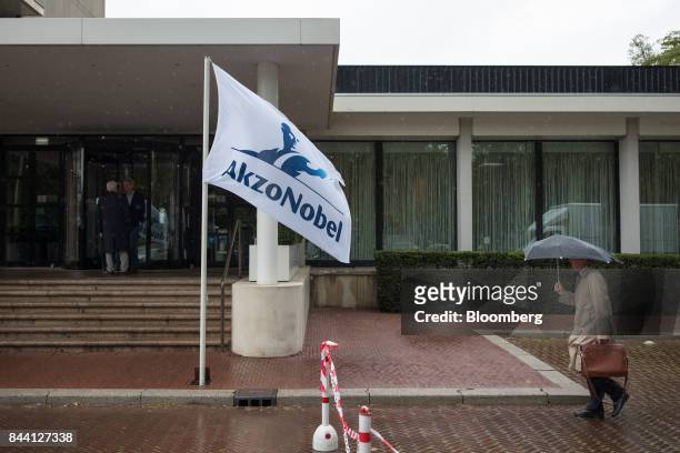 The Akzo Nobel NV logo sits on a flag flying outside the Hilton Amsterdam Hotel, the venue of the company's shareholder meeting in Amsterdam,...