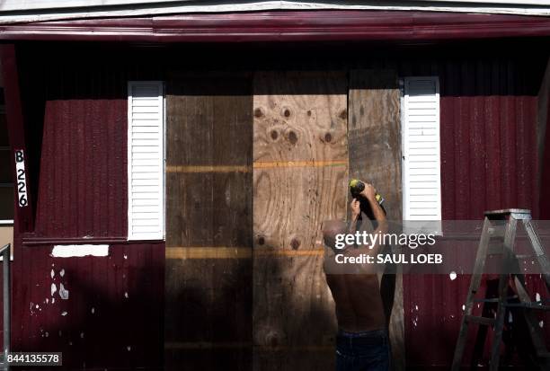 Man installs plywood over the windows of a mobile home at the Sunnyside Trailer Park during preparations for Hurricane Irma in West Miami, Florida,...