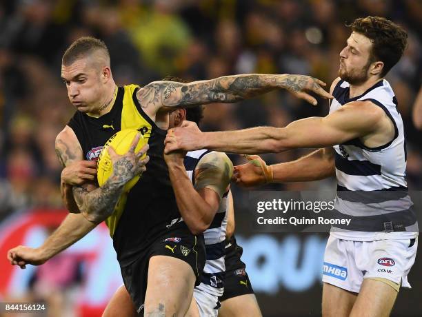 Dustin Martin of the Tigers fends off a tackle by Jordan Murdoch of the Cats during the AFL Second Qualifying Final Match between the Geelong Cats...