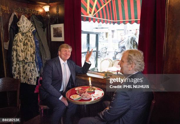 Dutch King Willem-Alexander sits with Amsterdam's mayor Eberhard van der Laan, as he visits the Amsterdam neighborhood the "Jordaan" in Amsterdam,...