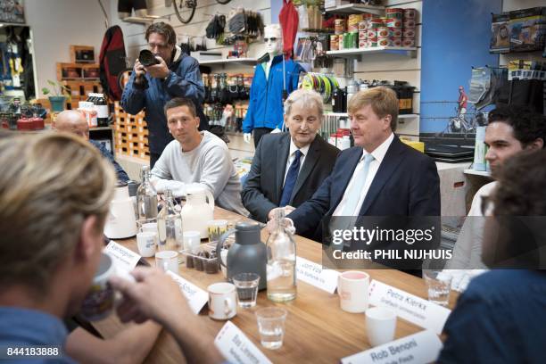 Dutch King Willem-Alexander sits with Amsterdam's mayor Eberhard van der Laan , as he visits the Amsterdam neighborhood the "Jordaan" in Amsterdam,...