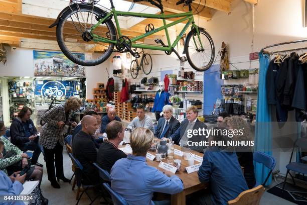 Dutch King Willem-Alexander sits with Amsterdam's mayor Eberhard van der Laan , as he visits the Amsterdam neighborhood the "Jordaan" in Amsterdam,...