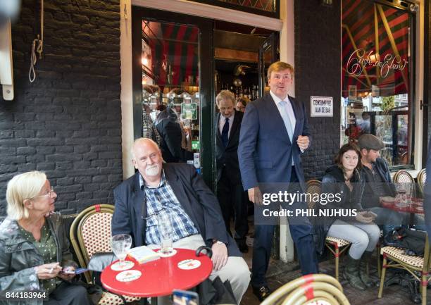 Dutch King Willem-Alexander leaves a cafe following by Amsterdam's mayor Eberhard van der Laan, as he visits the Amsterdam neighborhood the "Jordaan"...