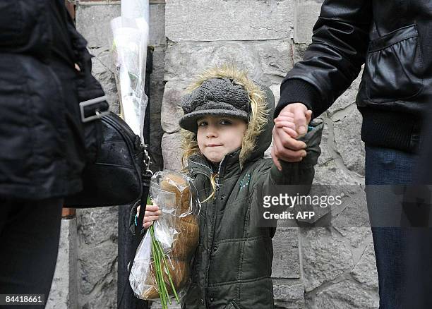 Child carries flowers in honour of the victims of the attack at the children's day care center 'Fabeltjesland' in Sint-Gillis, Dendermonde on January...