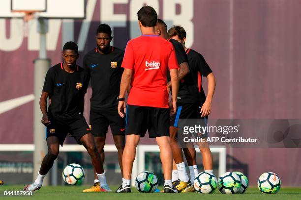 Barcelona's French forward Ousmane Dembele and Barcelona's French defender Samuel Umtiti eye a ball during a training session at the Sports Center FC...