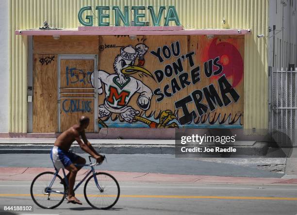 Message reading "You Don't Scare Us Irma" is written on plywood being used to cover the windows of a building as people prepare for the arrival of...