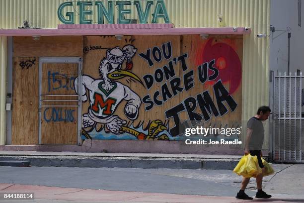 Message reading "You Don't Scare Us Irma" is written on plywood being used to cover the windows of a building as people prepare for the arrival of...