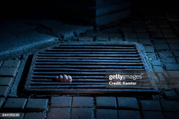 hands holding a manhole cover from underneath at night - prison escape stock pictures, royalty-free photos & images