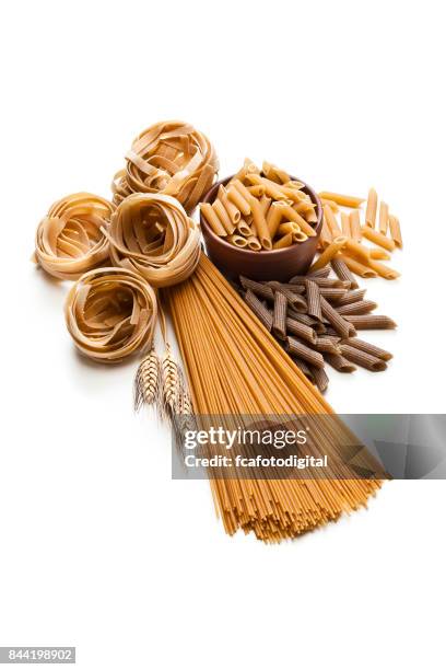 wholegrain pasta isolated on white background - whole wheat penne pasta stock pictures, royalty-free photos & images