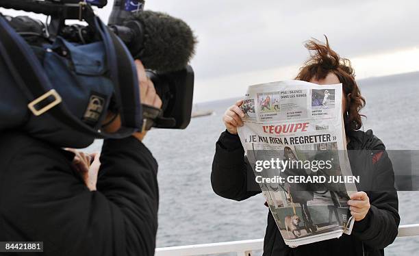 Journalist is filmed in Marseille on January 23, 2009 with the front page of French national sports daily L'Equipe from the day before showing what...