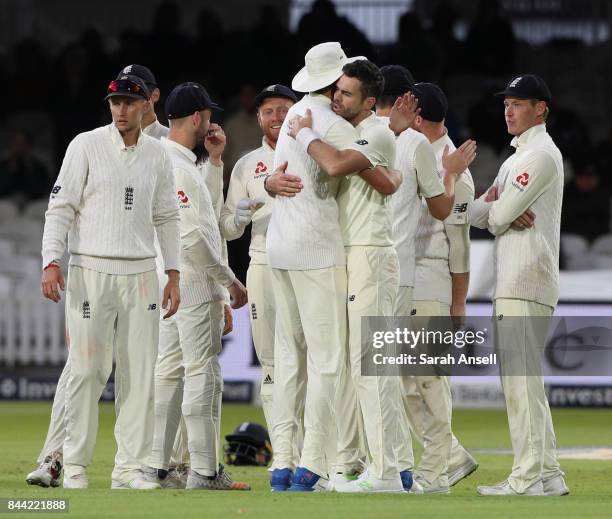 Jimmy Anderson of England is hugged by teammate Stuart Broad after taking his 501th Test wicket by bowling Kieran Powell of West Indies during day...