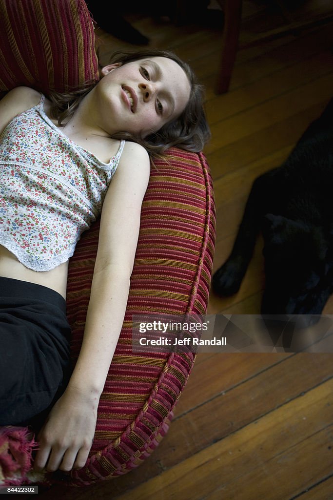 Pre-teen girl lying on chair in living room