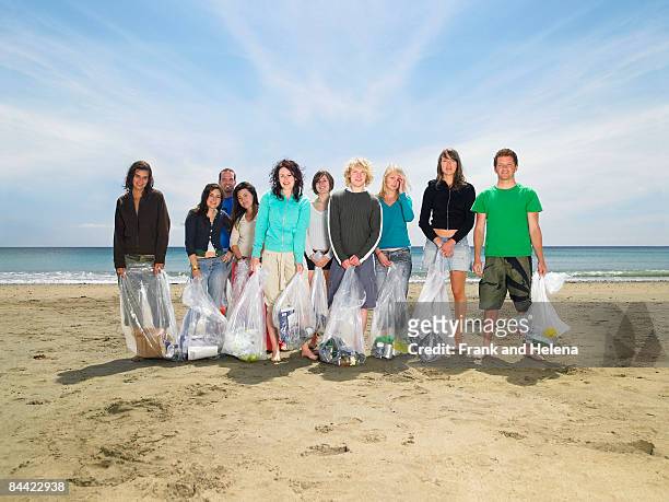 young people collecting garbage on beach - volunteer beach photos et images de collection