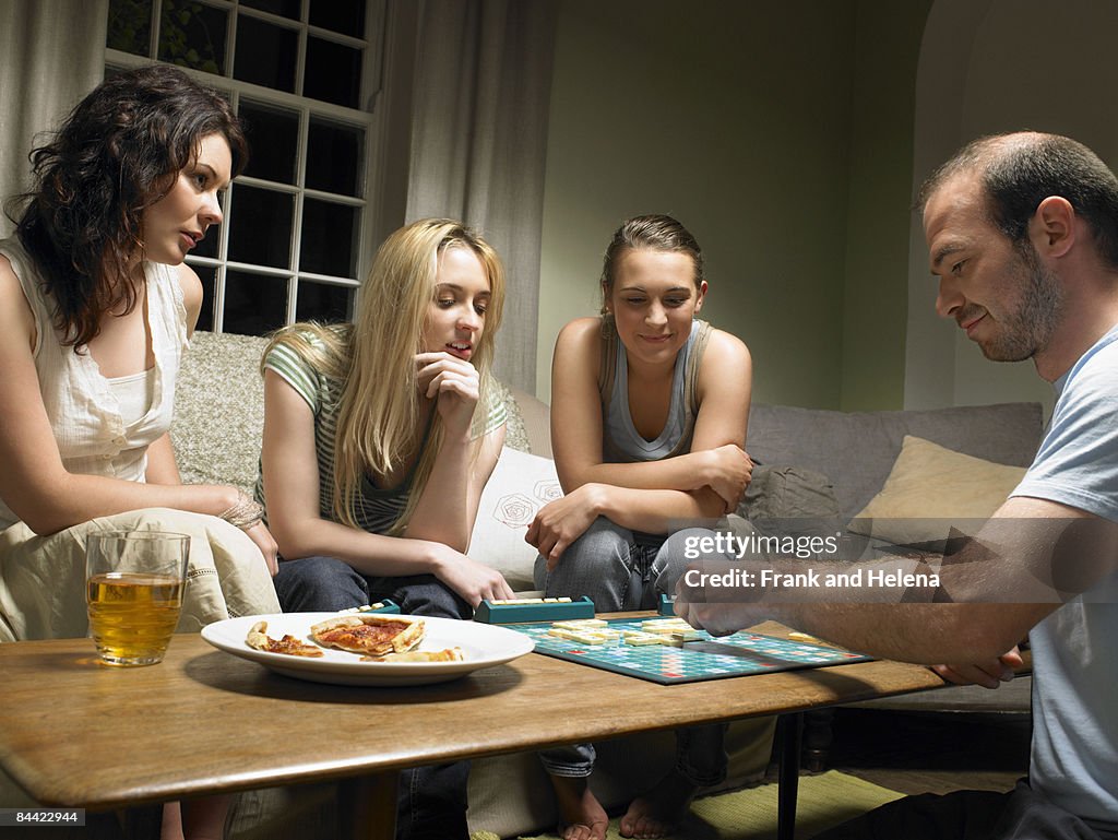 Four young people playing scrabble