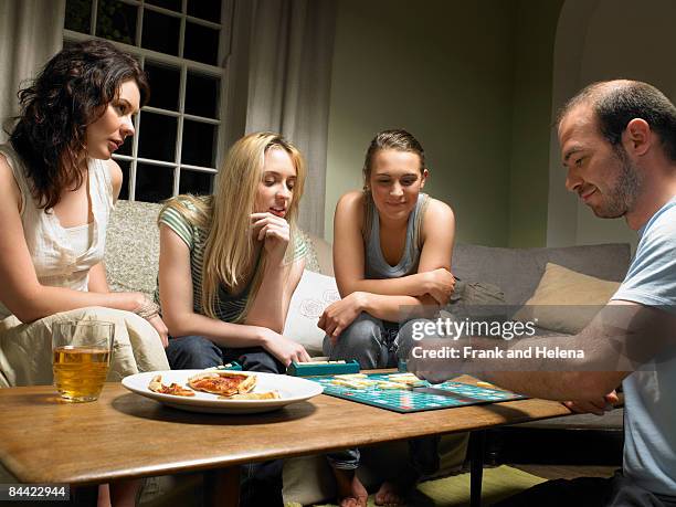 four young people playing scrabble - game night stock pictures, royalty-free photos & images