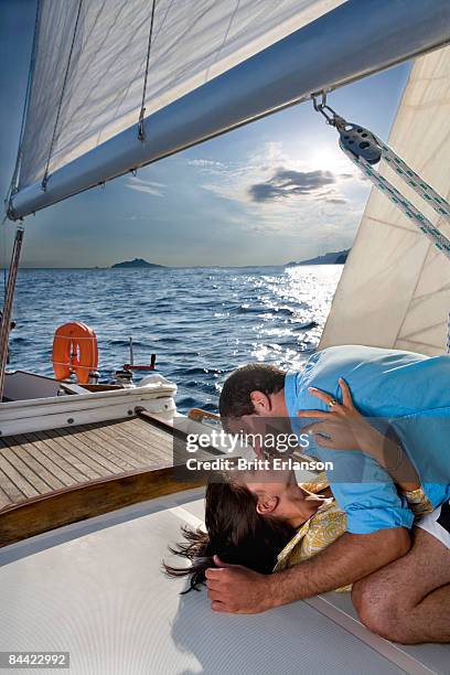 couple laying on sailboat, kissing - kiss booth stock-fotos und bilder