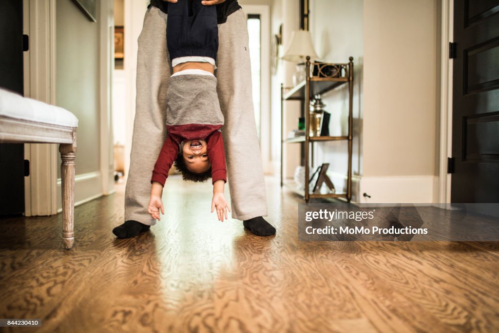 Father holding toddler son upside down