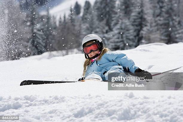 girl with skis lying on snow - skiing accident stock pictures, royalty-free photos & images
