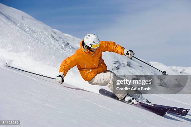 skier carving through powder snow - alpine skiing downhill stock pictures, royalty-free photos & images
