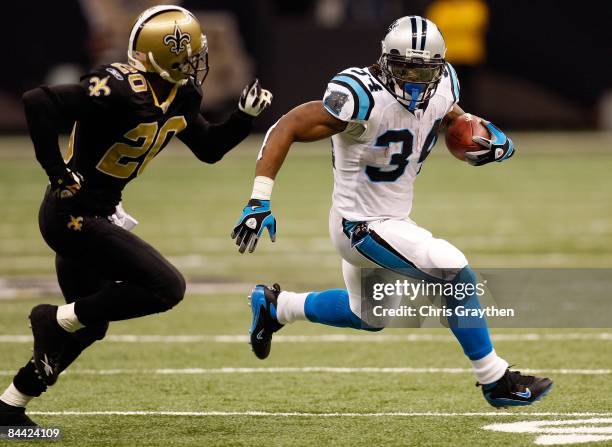 DeAngelo Williams of the Carolina Panthers avoids a tackle by Randall Gay of the New Orleans Saints on December 28, 2008 at the Superdome in New...