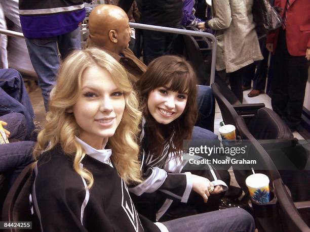 Recording artists Taylor Swift and Demi Lovato attend the NHL game between the Tampa Bay Lightning and the Los Angeles Kings on January 12, 2009 at...