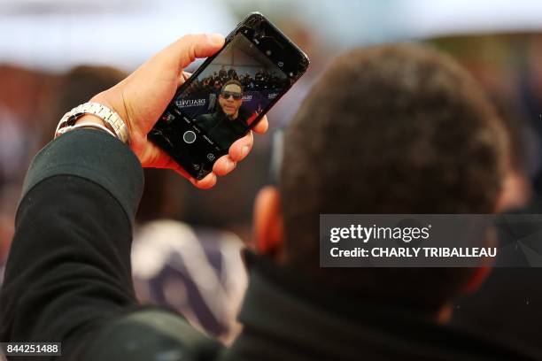 French singer Joey Starr takes a photo on the red carpet before the screening of the movie "Mother" on September 8, 2017 in the northwestern sea...