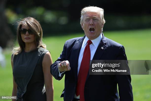 President Donald Trump, accompanied by first lady Melania Trump, shouts to reporters while departing the White House for Camp David September 8, 2017...