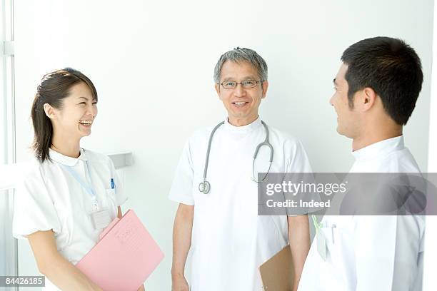 japanese doctor and nurses talking together - clipboard and glasses stock pictures, royalty-free photos & images
