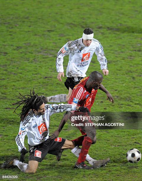 Ajaccio's forward Georges Ba vies with Vannes' defender Pierre Talmont and midfielder Stephane Auvray during their French Cup football match on...