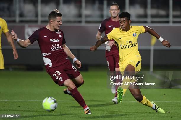 Paris Saint-Germain's French defender Presnel Kimpembe vies with Metz's Luxembourgian defender Chris Philipps during the French L1 football match...